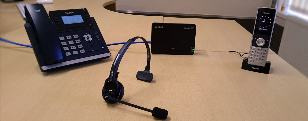 Business VoIP telephones and headset on an office desk